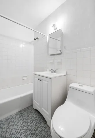 a white toilet sitting next to a bath tub