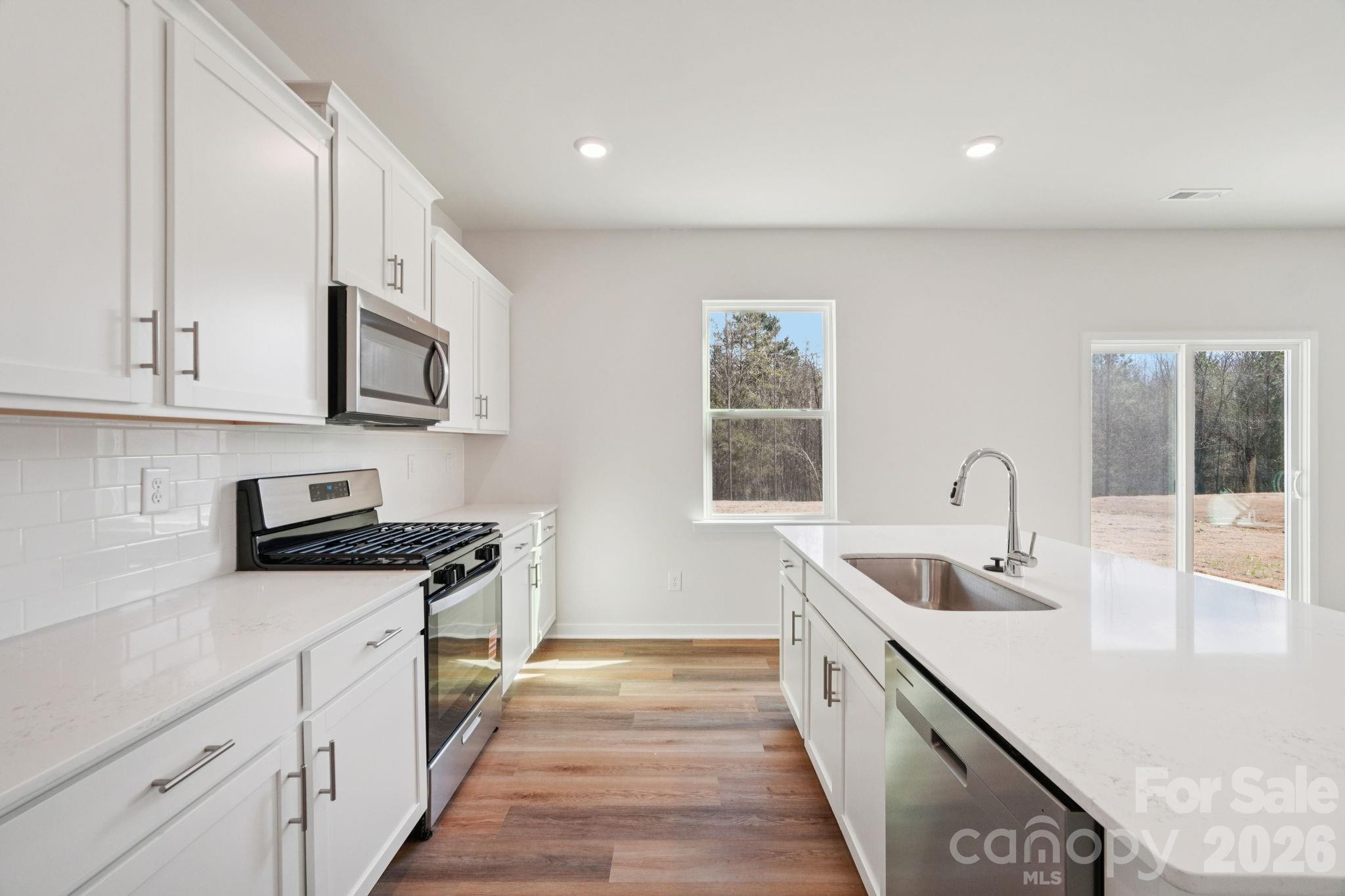 4559 Harris Elliot Road Lincolnton, NC 28092 - Photo 11 of 36 a kitchen with stainless steel appliances granite countertop a sink and dishwasher a stove top oven with wooden floor