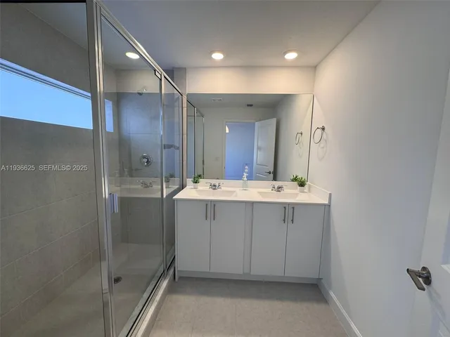 a bathroom with a shower sink mirror and toilet