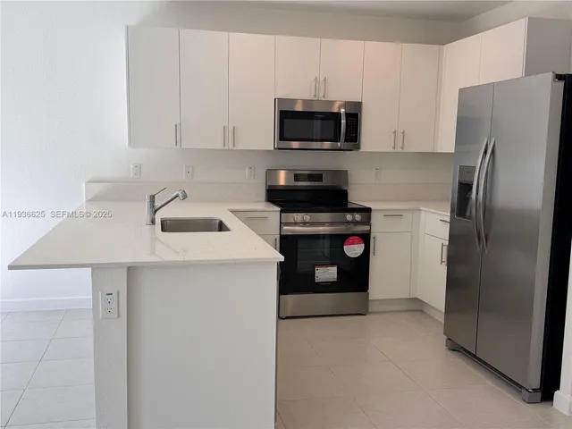 a kitchen with stainless steel appliances a refrigerator stove and microwave