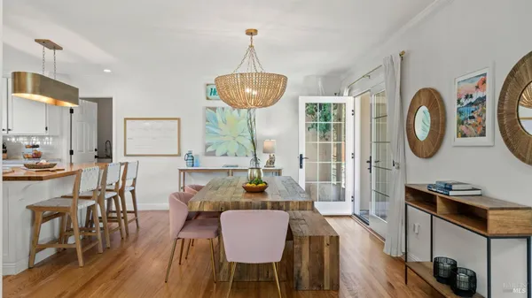 a view of a dining room with furniture a chandelier and wooden floor