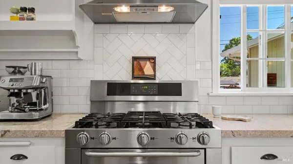 a stove top oven sitting inside of a kitchen
