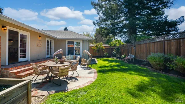 a view of a house with backyard and sitting area