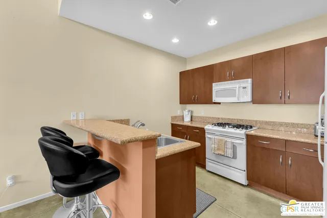 a kitchen with stainless steel appliances granite countertop a stove a sink and a microwave