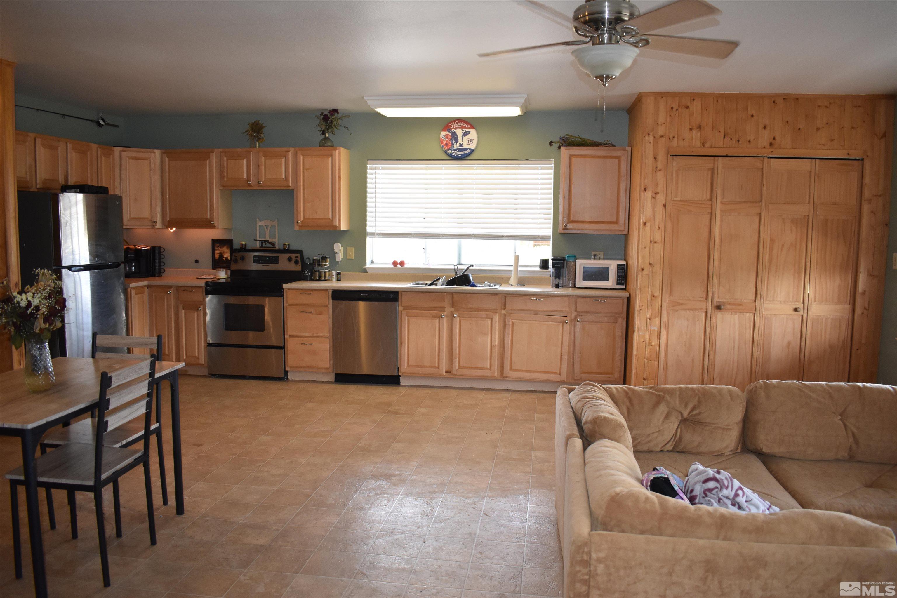 1737 Dee Jay Lane Minden, NV 89423 - Photo 11 of 40 a open kitchen with stainless steel appliances granite countertop a stove top oven a sink a dining table and chairs with wooden floor
