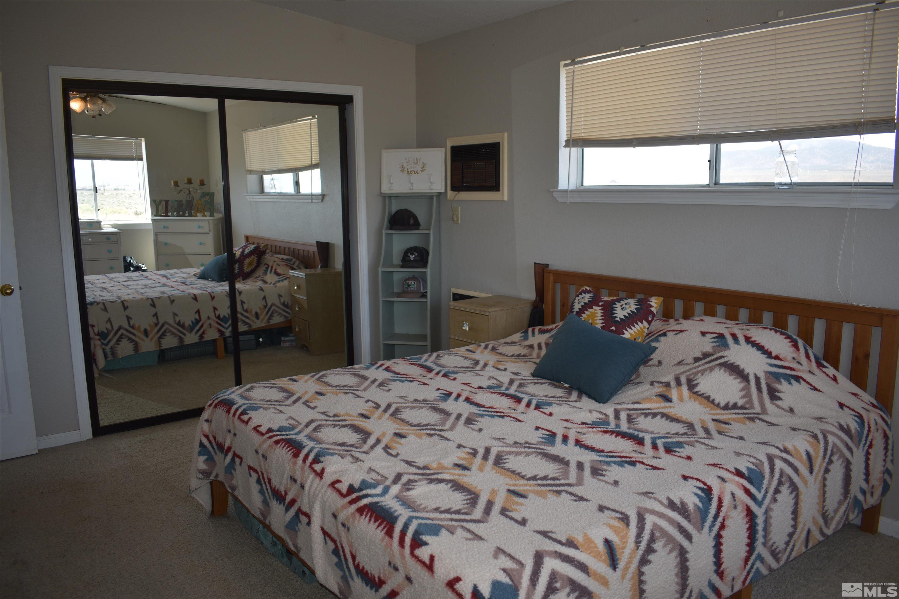 1737 Dee Jay Lane Minden, NV 89423 - Photo 12 of 40 a bedroom with a bed and large mirror next to a window