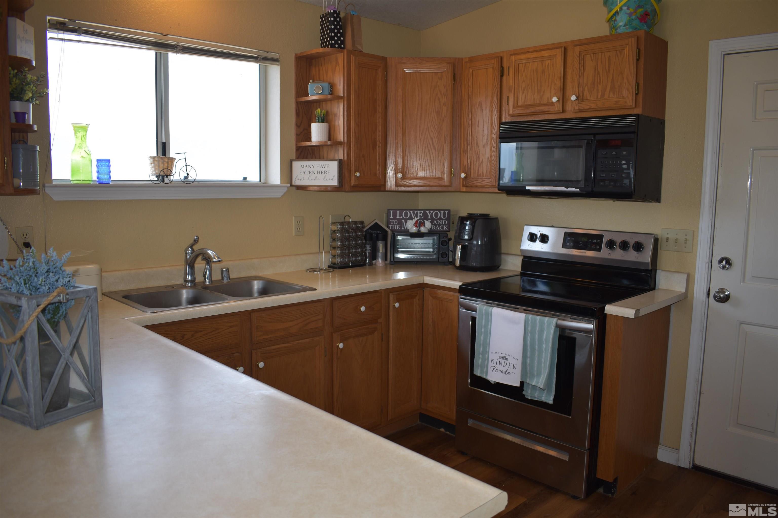 1737 Dee Jay Lane Minden, NV 89423 - Photo 18 of 40 a kitchen with stainless steel appliances granite countertop a sink stove and microwave