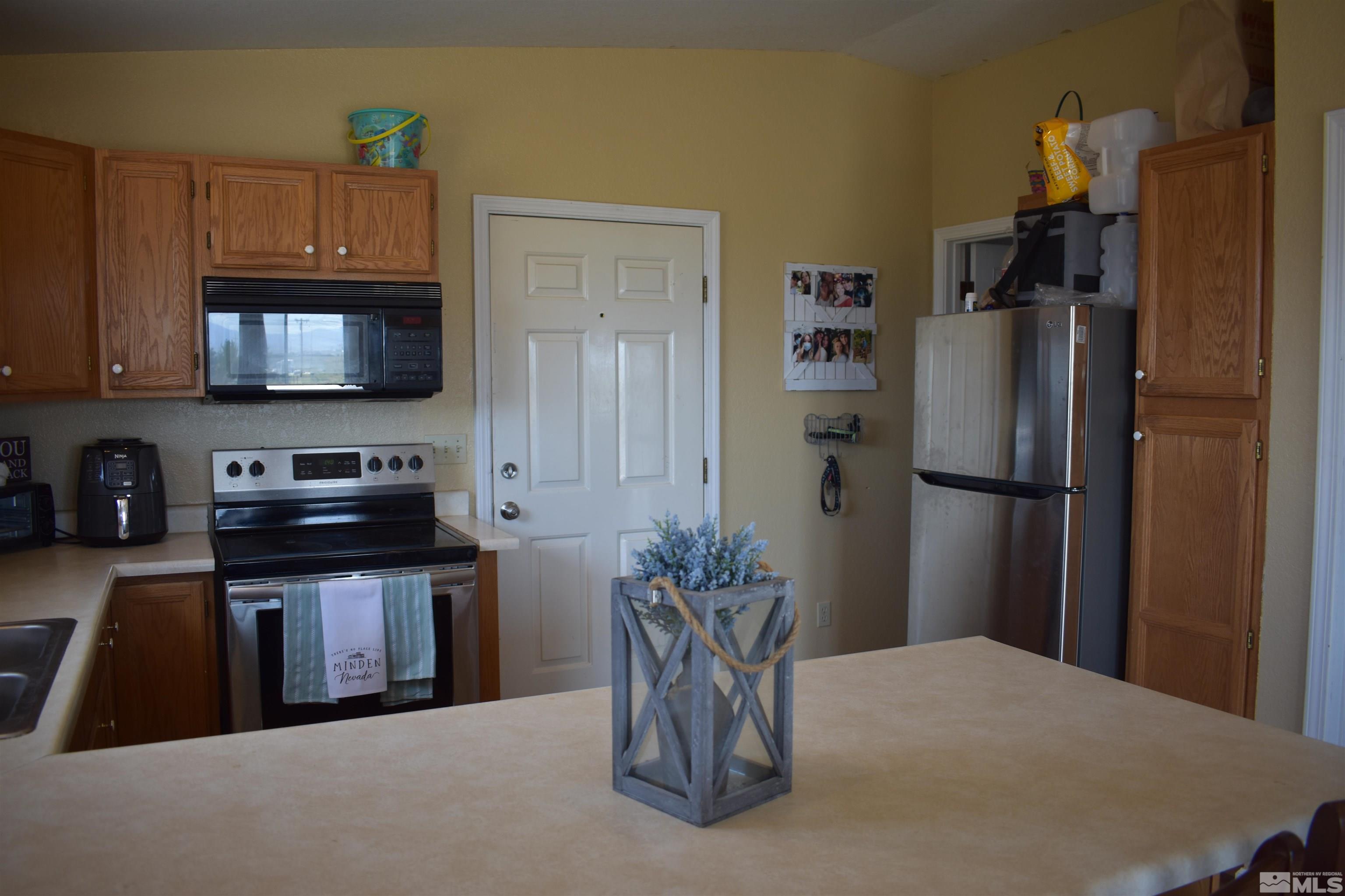 1737 Dee Jay Lane Minden, NV 89423 - Photo 19 of 40 a kitchen with stainless steel appliances granite countertop a refrigerator a stove top oven a sink dishwasher and microwave