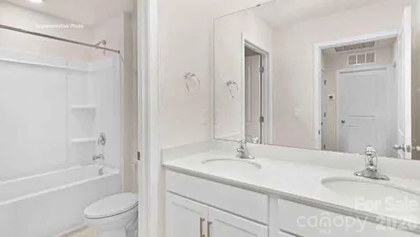 a bathroom with a granite countertop sink a toilet and shower