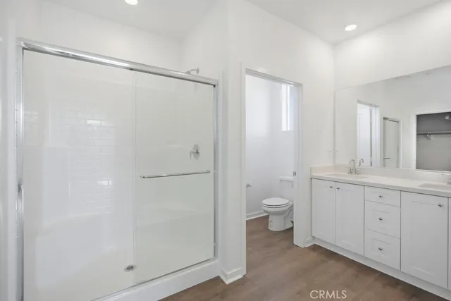 a bathroom with a double vanity sink toilet and shower