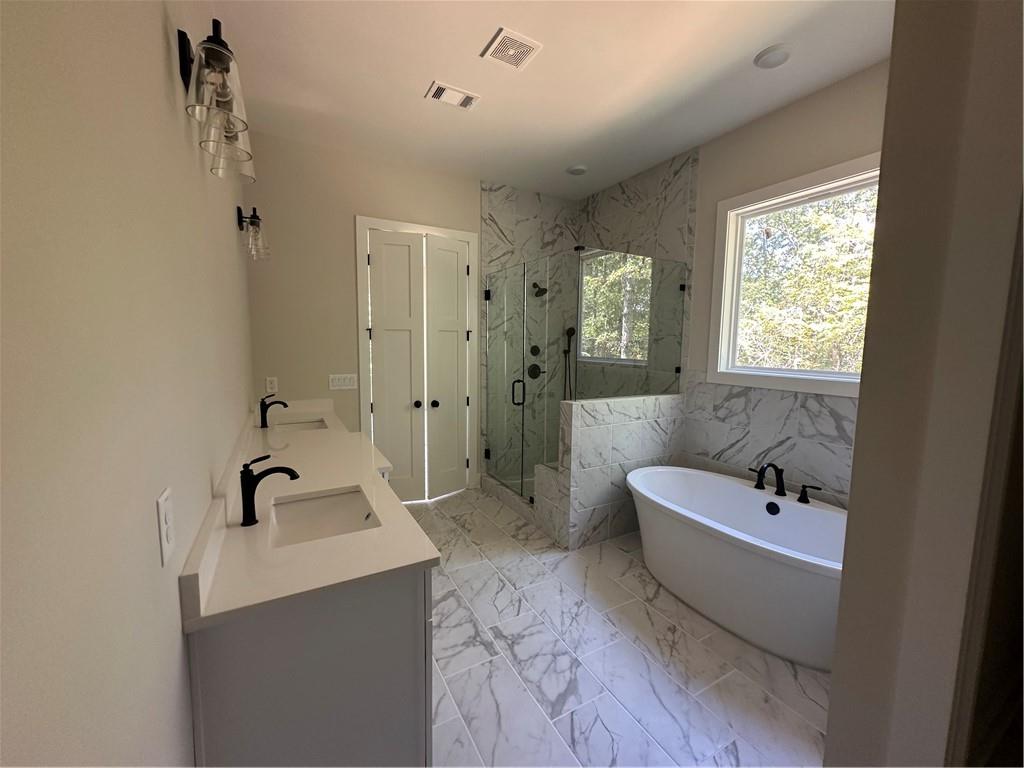 967 Cable Road Waleska, GA 30183 - Photo 4 of 27 a bathroom with a bathtub a sink a window and shower