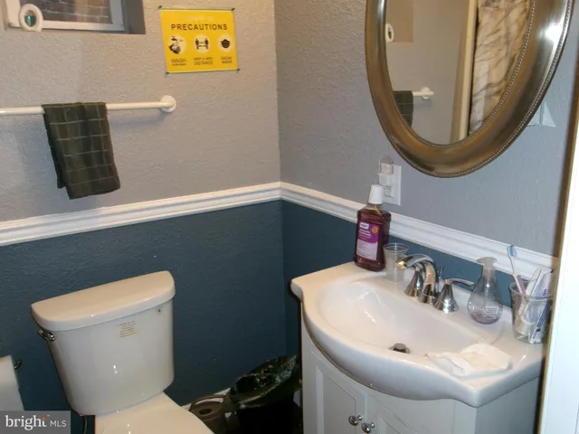 a bathroom with a toilet a sink and mirror