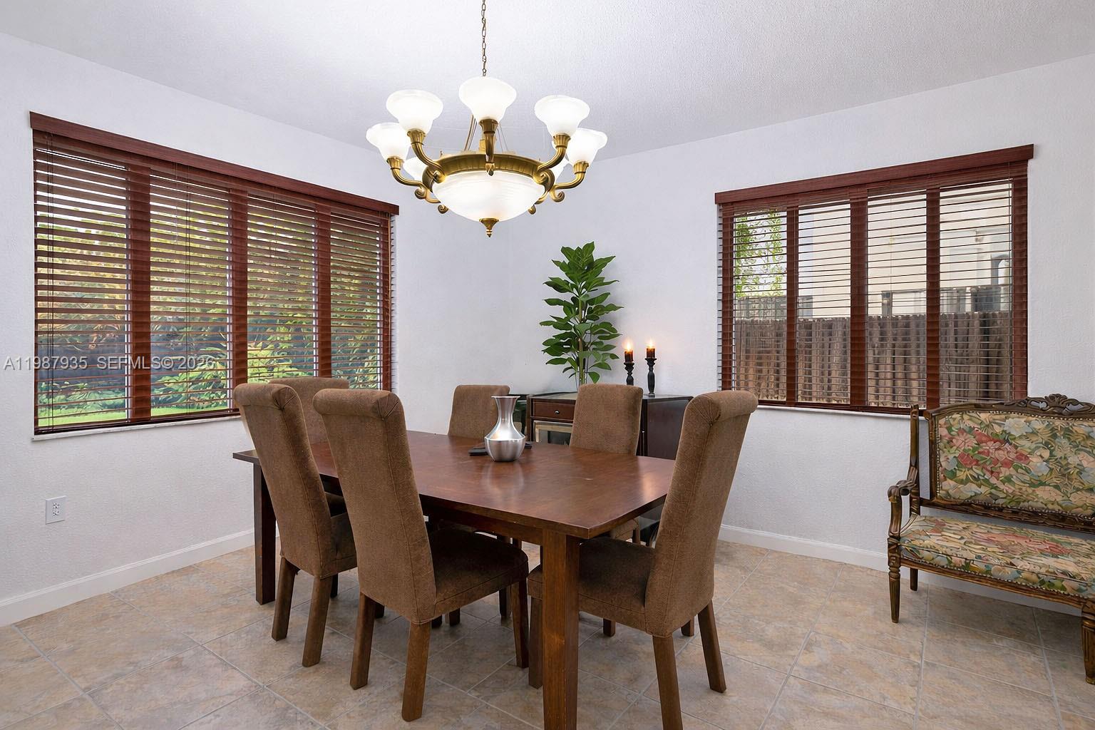 16479 Southwest 50th Terrace Miami, FL 33185 - Photo 14 of 51 a view of a dining room with furniture wooden floor and chandelier