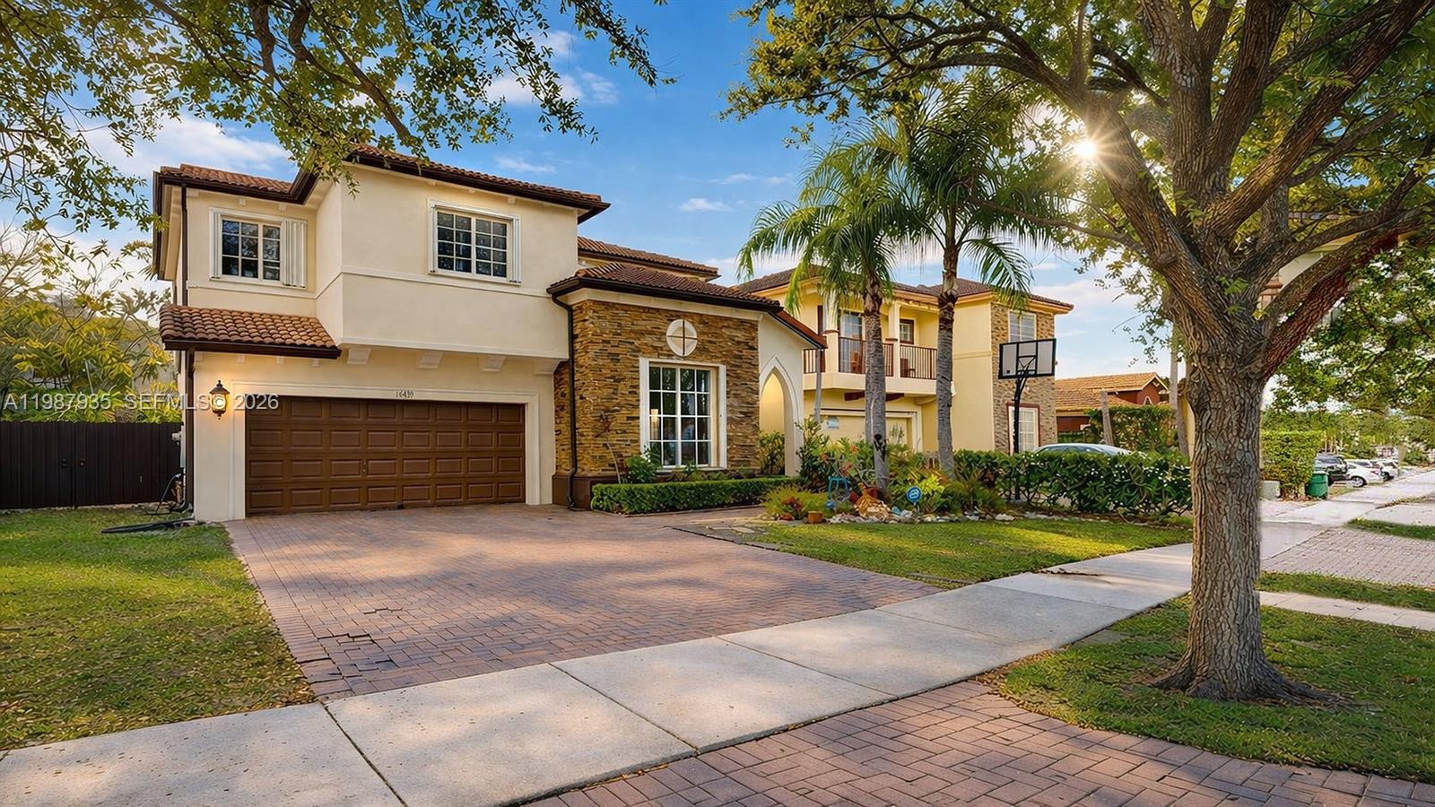 16479 Southwest 50th Terrace Miami, FL 33185 - Photo 2 of 51 a front view of a house with a garden and trees