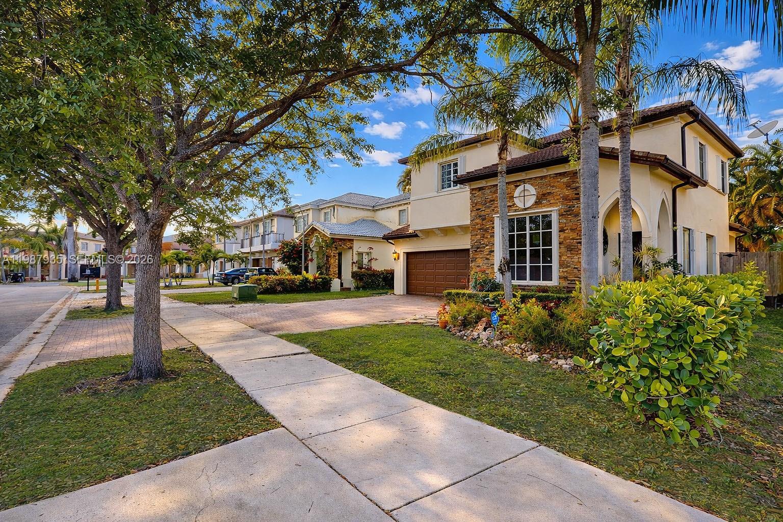 16479 Southwest 50th Terrace Miami, FL 33185 - Photo 3 of 51 a front view of a building with a garden and trees