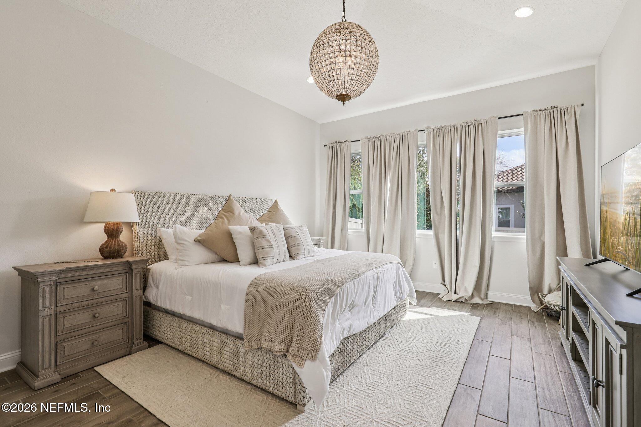 97 Rialto Drive Ponte Vedra, FL 32081 - Photo 12 of 48 a bedroom with a bed and a chandelier
