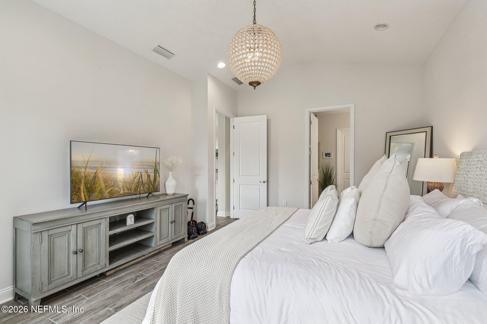 97 Rialto Drive Ponte Vedra, FL 32081 - Photo 14 of 48 a bedroom with a large bed and a flat tv screen on dresser