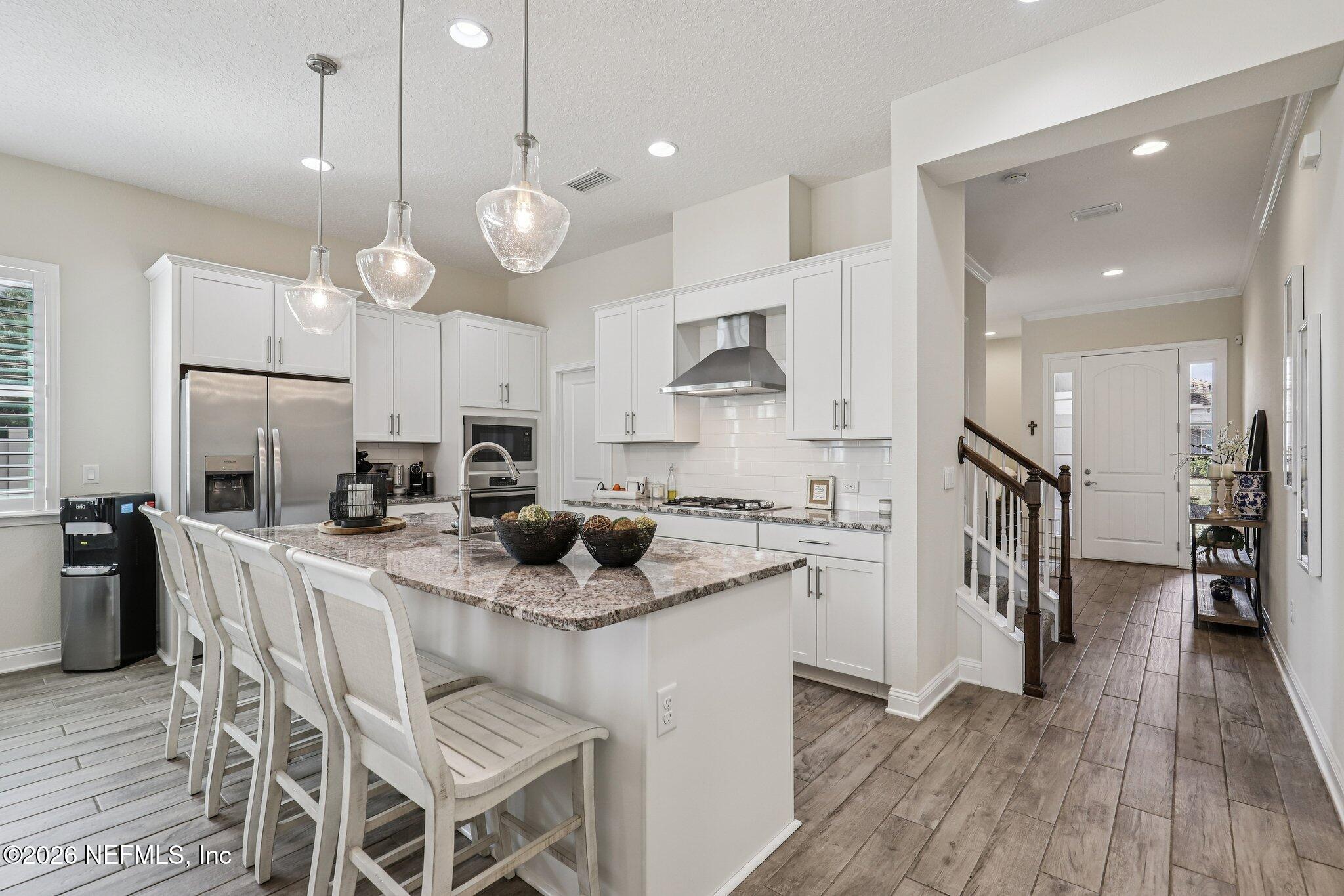 97 Rialto Drive Ponte Vedra, FL 32081 - Photo 5 of 48 a kitchen with stainless steel appliances kitchen island granite countertop a stove a sink a center island a refrigerator and cabinets