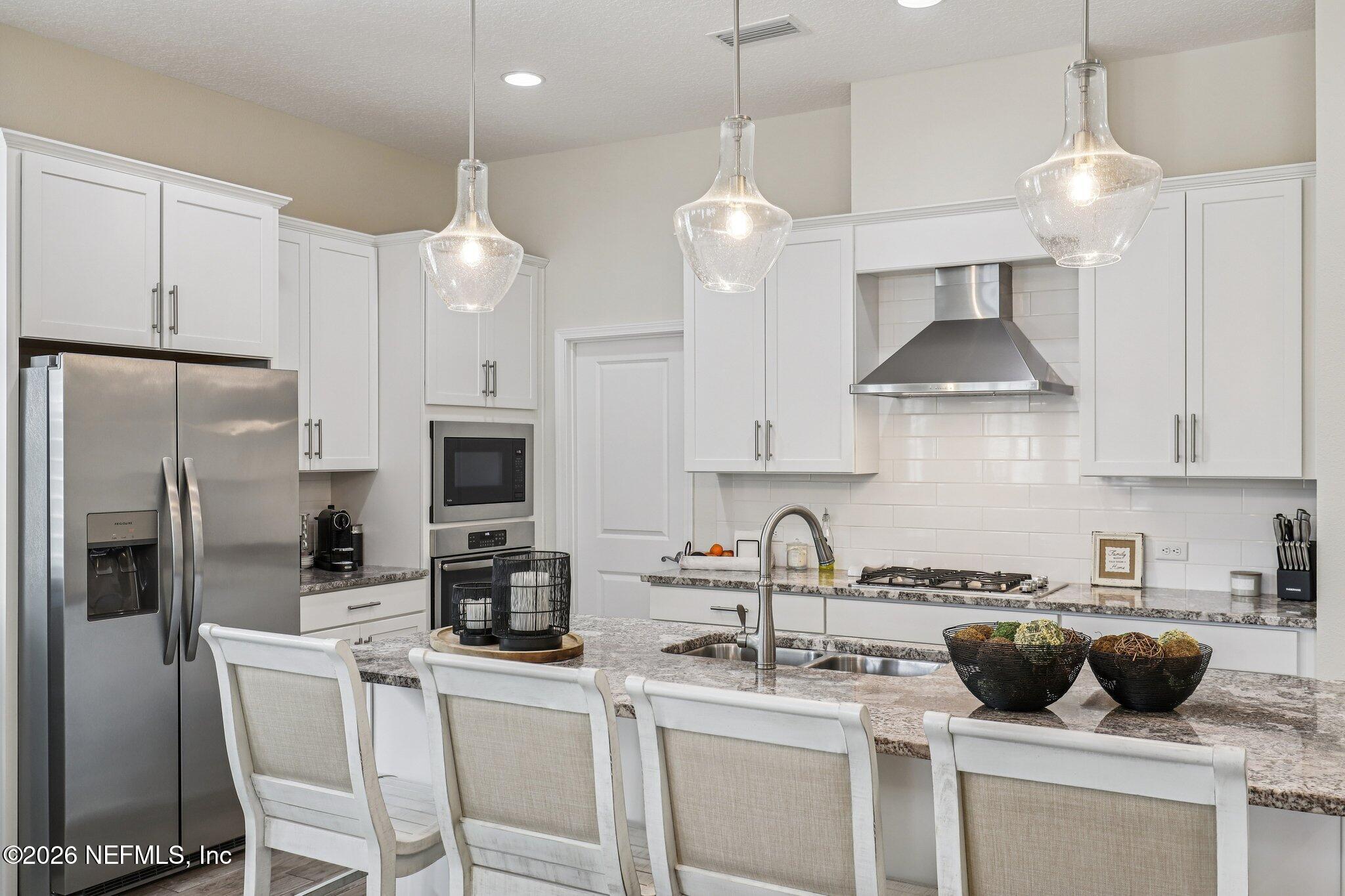 97 Rialto Drive Ponte Vedra, FL 32081 - Photo 6 of 48 a kitchen with stainless steel appliances a stove a sink a refrigerator a center island a stove and cabinets