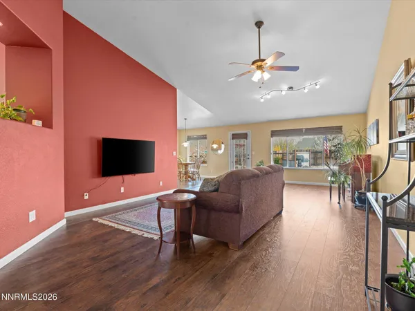 a living room with furniture a ceiling fan and a flat screen tv