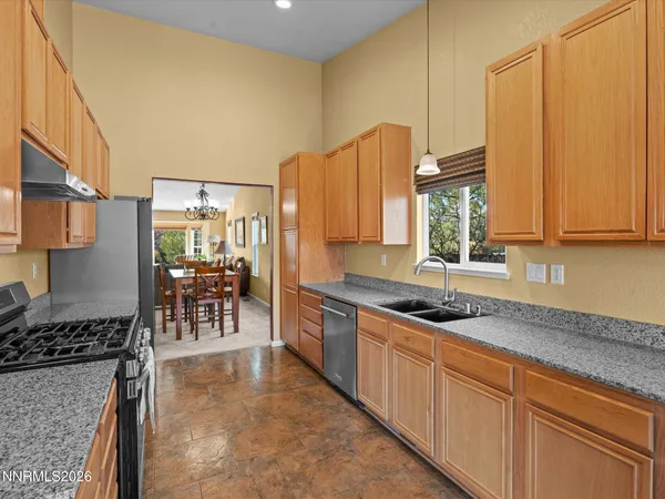 a kitchen with stainless steel appliances granite countertop a sink a stove a microwave a counter top space and cabinets