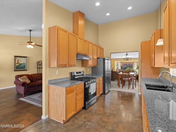 a kitchen with stainless steel appliances granite countertop a stove a sink and a microwave