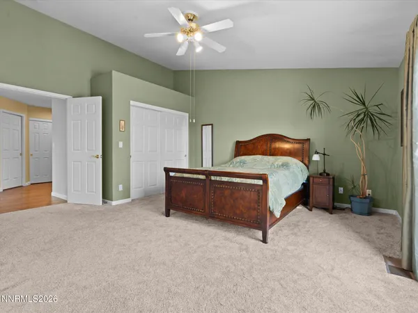a bed sitting in a spacious bedroom next to a bedroom