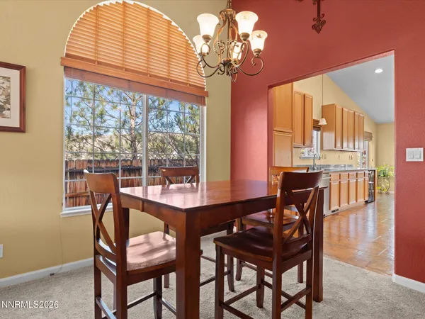 a dining room with furniture a chandelier and wooden floor