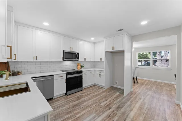 a kitchen with granite countertop stainless steel appliances and wooden cabinets