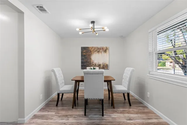 a dining room with furniture a chandelier and wooden floor