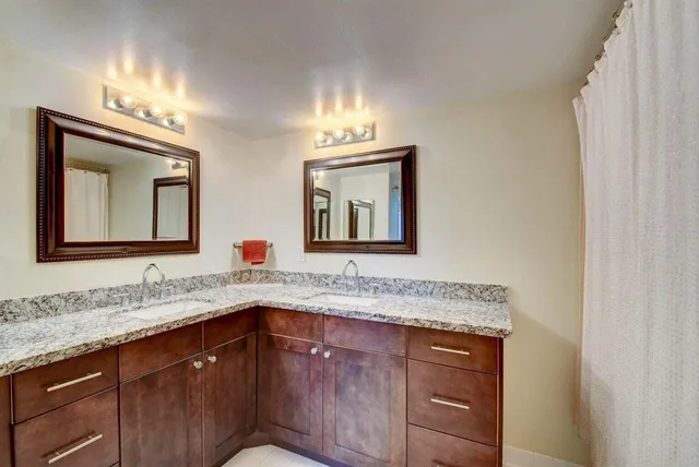 a bathroom with a granite countertop sink and a mirror