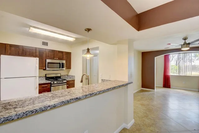 a kitchen with granite countertop a sink and a stove top oven