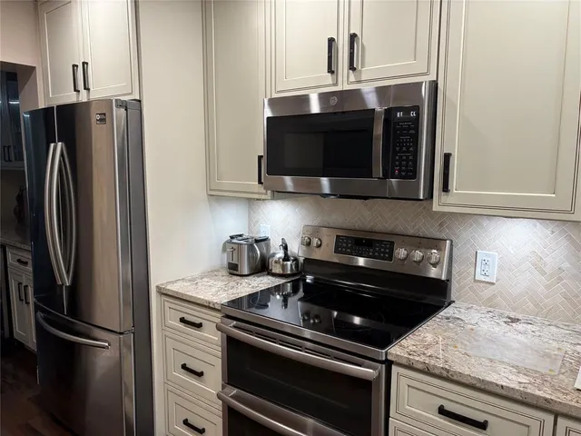 a kitchen with stainless steel appliances granite countertop a refrigerator stove and microwave