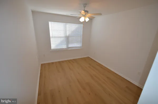 a view of an empty room with a chandelier fan