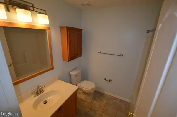 an empty room with windows and chandelier fan