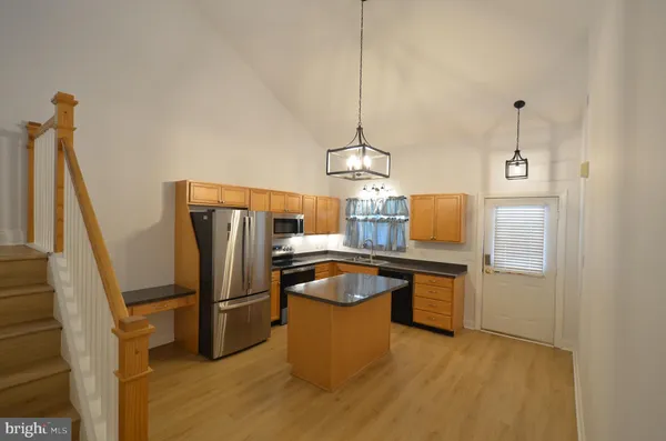 a room with kitchen island a counter top space and stainless steel appliances