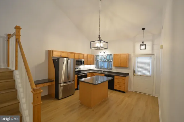 a room with kitchen island a counter top space and stainless steel appliances