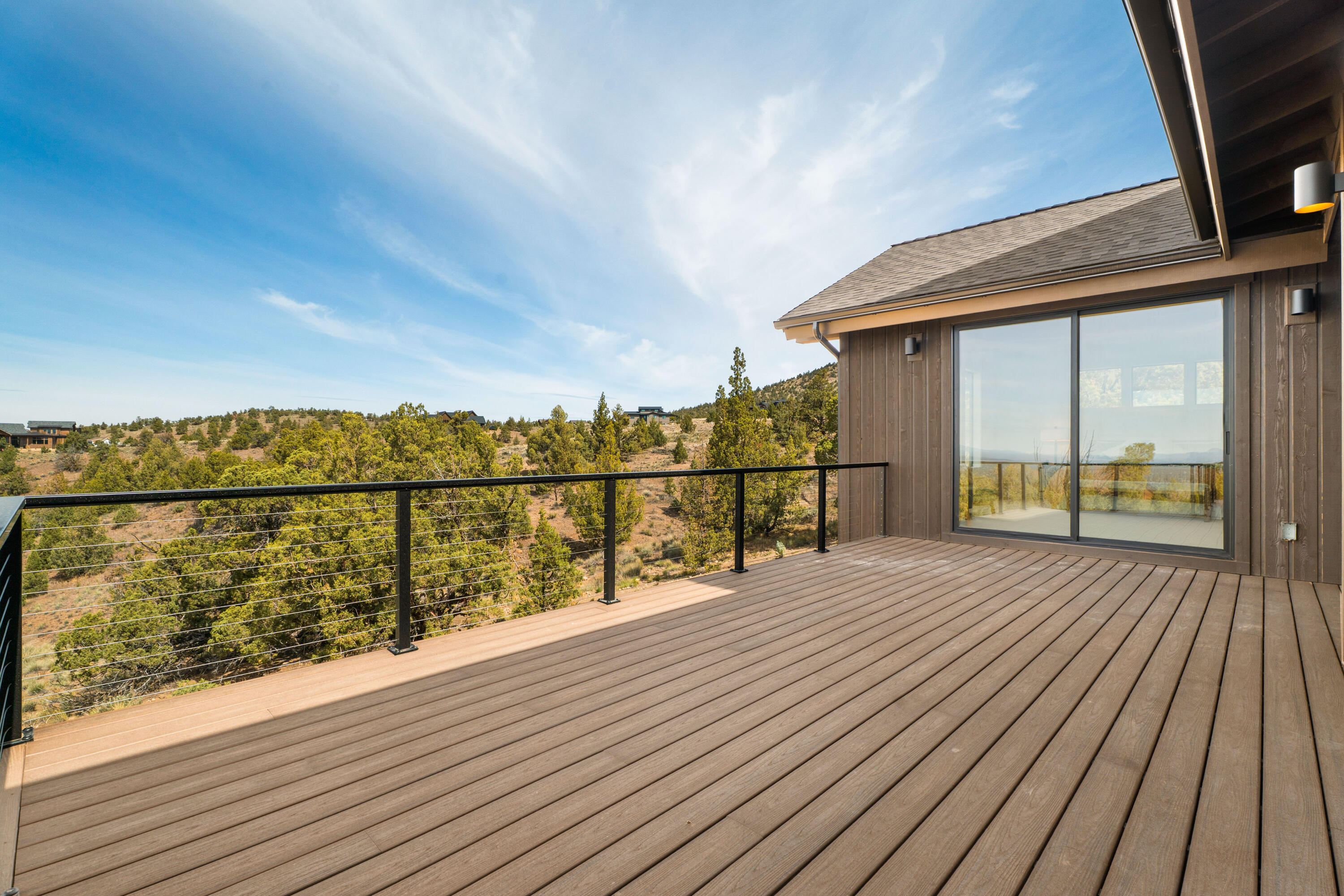 16883 Southwest Paragon Court Powell Butte, OR 97753 - Photo 16 of 42 Oversized doors of full glass lead to the primary suite deck, that does connect to the rest of the back deck but is set back for privacy