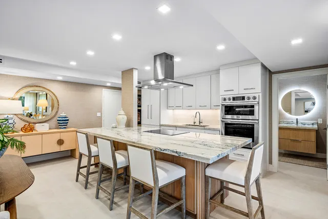a kitchen with microwave a stove and chairs