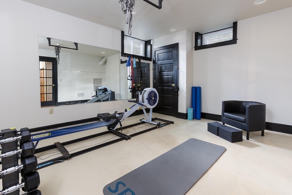 57 Hedge Road Brookline, MA 02445 - Photo 32 of 37 a room with gym equipment and a flat screen tv