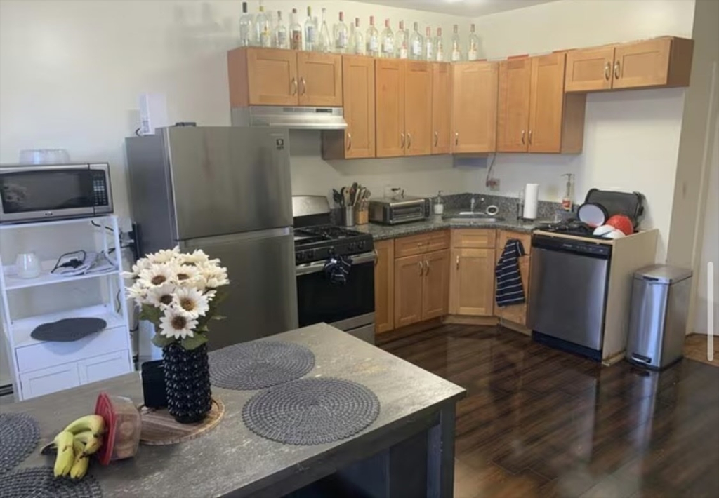 1576 Tremont Street, Unit 2 Boston, MA 02120 - Photo 7 of 13 a kitchen with a refrigerator and a stove