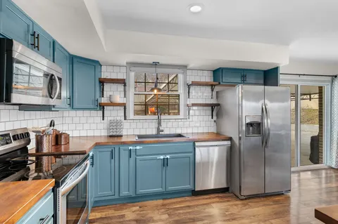 a kitchen with stainless steel appliances granite countertop a sink stove and refrigerator