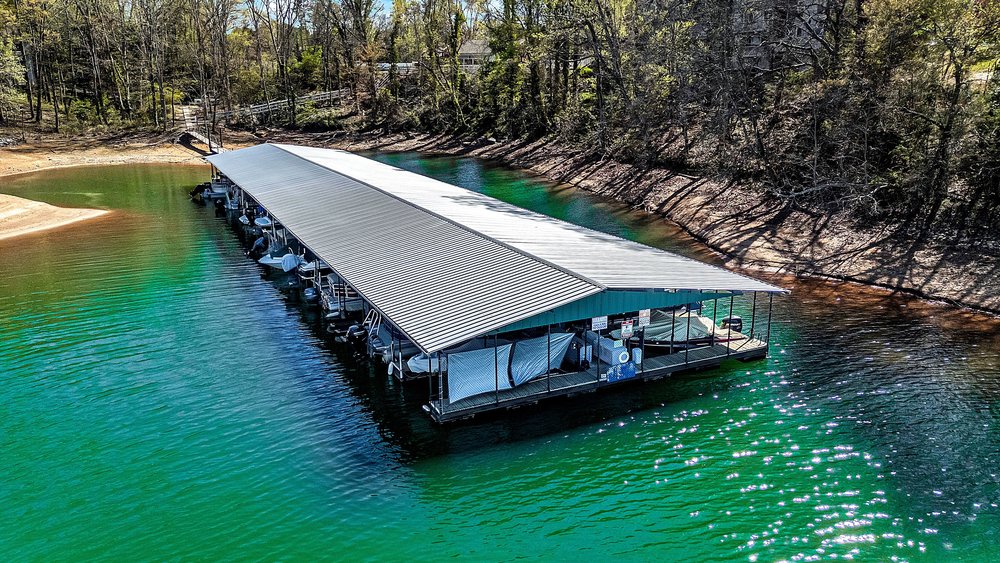 21 Harbor Gate Anderson, SC 29625 - Photo 4 of 44 Boathouse with covered boat slips in a serene lake setting with mature trees.
