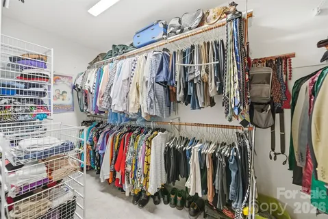 a view of walk in closet with clothes and shoes