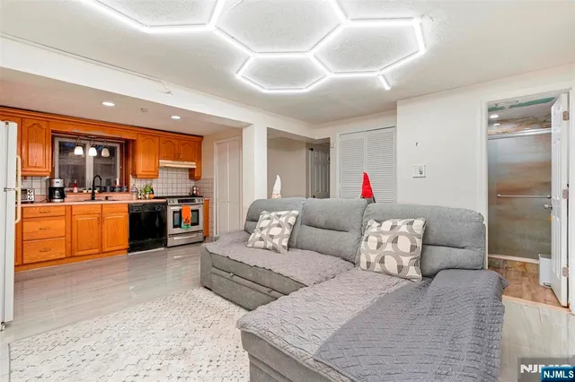 a living room with furniture kitchen view and a large window