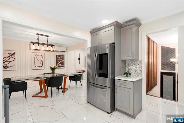 a kitchen with stainless steel appliances kitchen island granite countertop dining table chair and a refrigerator