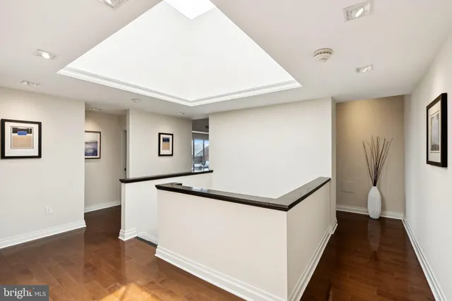 a hallway with white cabinets and wooden floor