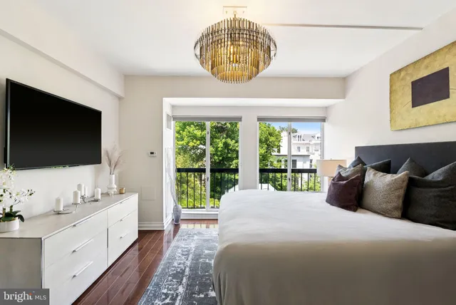 a bedroom with a large bed and a flat tv screen on dresser