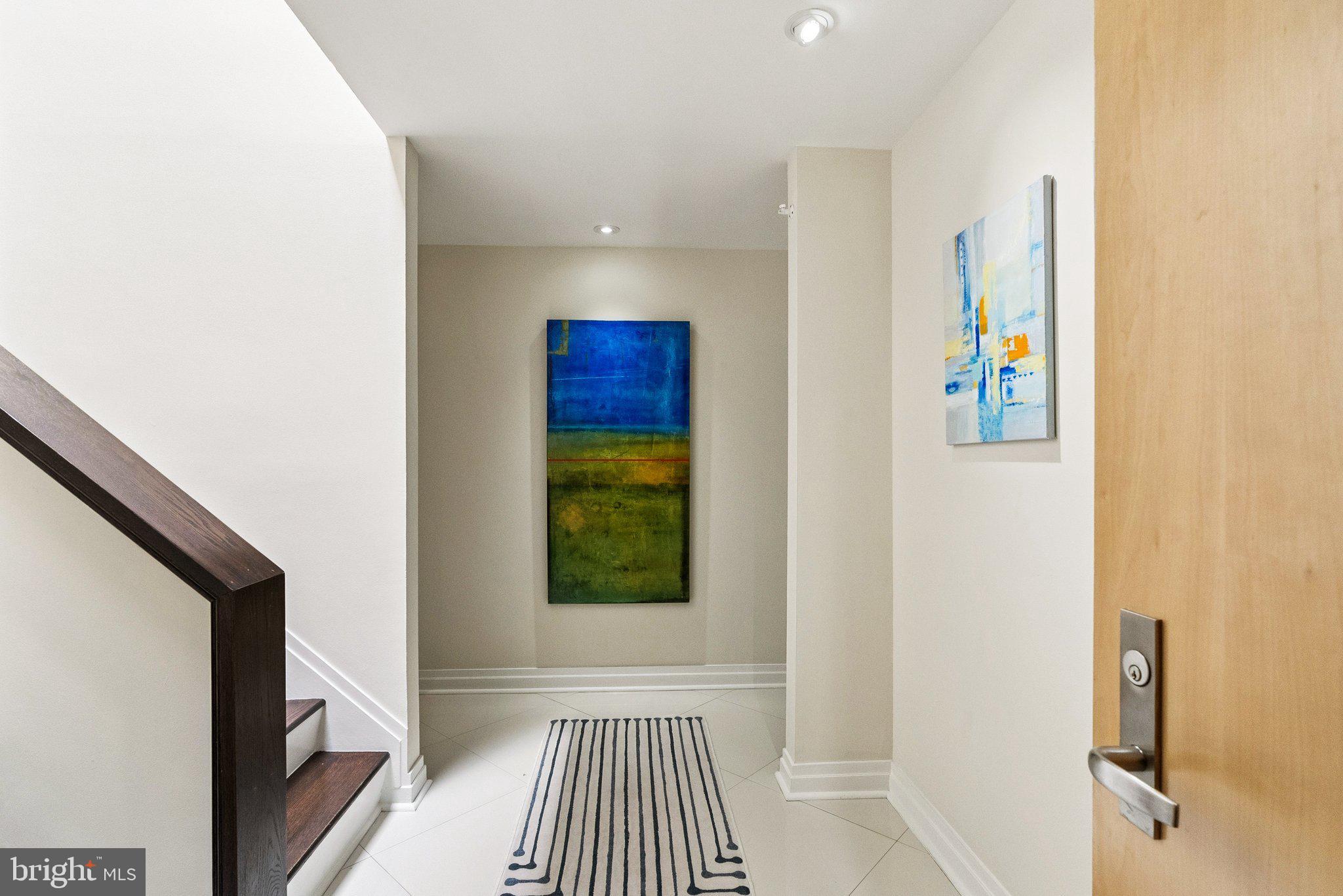 3251 Prospect Street Northwest, Unit 402 Washington, DC 20007 - Photo 2 of 36 a view of a hallway with wooden floor and a bathroom