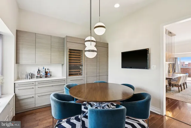 a living room with furniture a flat screen tv and kitchen view